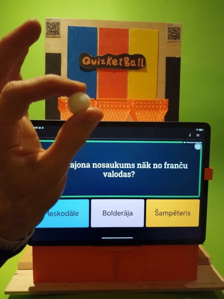 Quizketball device: a tablet quiz in front of three colored baskets